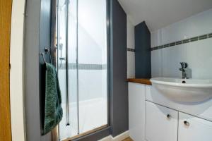 ein Bad mit einem Waschbecken und einer Glasdusche in der Unterkunft The Nest - cosy and quiet 1 bed central in Buckinghamshire