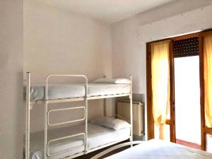 2 Etagenbetten in einem Zimmer mit Fenster in der Unterkunft Holiday home in Rosolina Mare 24967 in Rosolina Mare