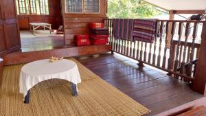 a porch with a white table and a rug at Eden Farmstay CNX 