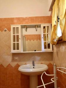 ein Bad mit einem Waschbecken und einem Spiegel in der Unterkunft Holiday home in Rosolina Mare 24967 in Rosolina Mare