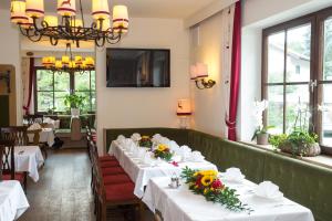 una fila di tavoli in un ristorante con dei fiori sopra di Landgasthof Rechenwirt a Elsbethen