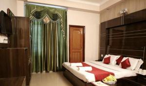 a bedroom with a large bed with a green curtain at Vipul Palace, katra in Katra