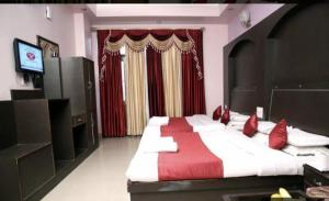 a large bedroom with a large bed with red pillows at Vipul Palace, katra in Katra