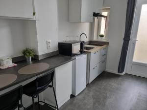 a small kitchen with a sink and a microwave at La Fourmi in Soissons +2 photos