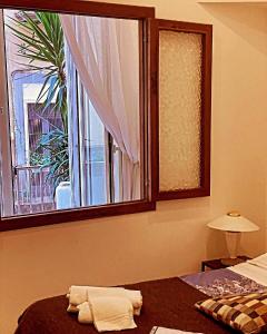 una camera da letto con finestra e un letto con asciugamani di Bed & Breakfast Plebiscito Home a Napoli