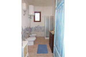 uma casa de banho com 2 WC, um lavatório e um chuveiro em Casa Tirreno 2 em San Teodoro