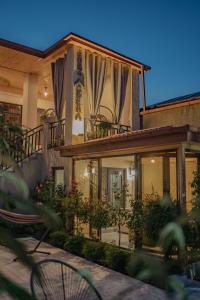 a house with a balcony with curtains on it at Kera Rooms in Tʼelavi