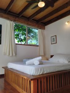 a bedroom with a large bed with a window at Tema'e Beach House in Temae