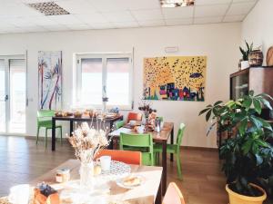 Agri B&B Terre Joniche في ايزولا كابو ريزوتو: غرفة طعام مع طاولات وكراسي خضراء