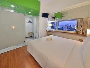 Postel nebo postele na pokoji v ubytování Whiz Hotel Pemuda Semarang + 18 fotografií