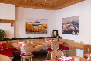 un restaurante con mesas, sillas y pinturas en la pared en Hotel Corvatsch, en St. Moritz