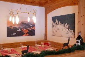 a dining room with a table and a painting on the wall at Hotel Corvatsch in St. Moritz