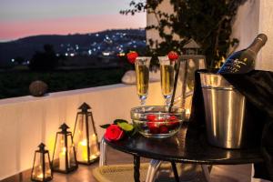 a table with two champagne glasses and a bowl of fruit at Villa Iliovasilema Santorini in Akrotiri