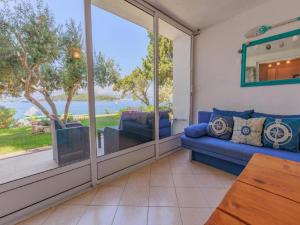 ein Wohnzimmer mit einem Sofa und Blick auf das Wasser in der Unterkunft Lumbarda Resort Apartments in Lumbarda