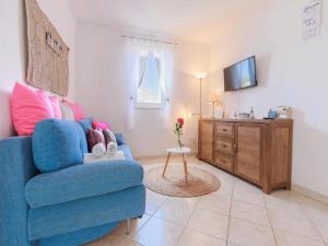 ein Wohnzimmer mit einem blauen Stuhl und einem TV in der Unterkunft Lumbarda Resort Apartments in Lumbarda