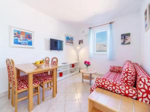 a kitchen and living room with a table and a couch at Lumbarda Resort Apartments in Lumbarda