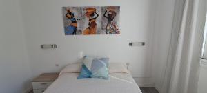 a bedroom with a bed with a painting on the wall at Paula Beach Malaga in Málaga