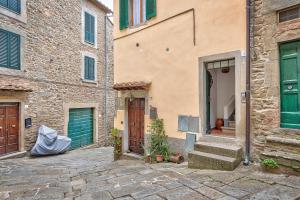- un bâtiment avec des portes et des escaliers verts à côté dans l'établissement Casa Marisa - Together in Tuscany, à Cortone