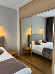 a hotel room with two beds and a mirror at Appartement Rue Grimaldi in Nice