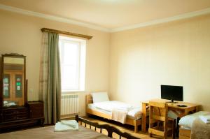 Zimmer mit 2 Betten und einem Schreibtisch mit einem TV in der Unterkunft Azhdahak B&B in Geghashen , Abovyan in Geghashen