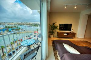 - un salon avec un balcon offrant une vue sur l'océan dans l'établissement Luxury & stylish 2bedroom seafront, balcony GOGZR-4, à Il-Gżira