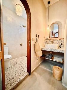een badkamer met een wastafel, een toilet en een spiegel bij Abdi Hotel in Gili Trawangan