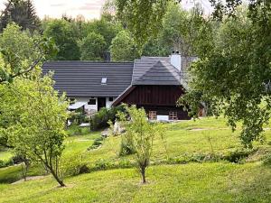 ein Haus inmitten eines Feldes mit Bäumen in der Unterkunft Chalupa U Vincků in Stachy