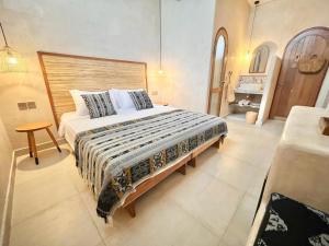 ein Schlafzimmer mit einem großen Bett und einem Tisch in der Unterkunft Abdi Hotel in Gili Trawangan