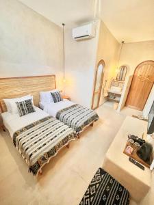 twee bedden naast elkaar in een kamer bij Abdi Hotel in Gili Trawangan