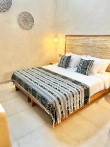 a bedroom with a large bed with a wooden headboard at Abdi Hotel in Gili Trawangan