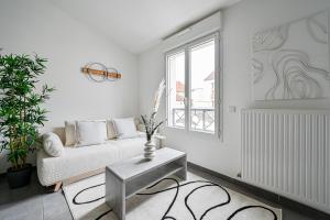 a white living room with a couch and a table at Le Nid - Proche Paris & Disney - Parking - WIFI in Villiers-sur-Marne