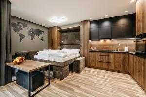 a bedroom with a bed and a table and a kitchen at Apartament 4a Park City in Ostrów Wielkopolski +14 photos