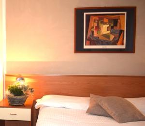 1 dormitorio con 1 cama y una foto en la pared en Albergo Canella, en Fuipiano Valle Imagna
