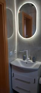 een badkamer met een wastafel en een spiegel bij Vikendica Striček in Kupres