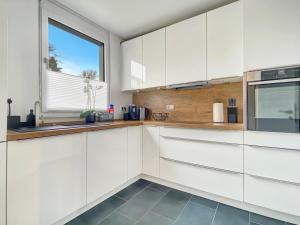 a kitchen with white cabinets and a window at Ferienhaus 500m zur Messe Hannover in Hannover