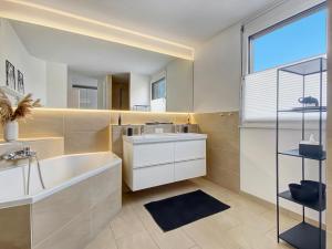 a bathroom with a tub and a sink and a mirror at Ferienhaus 500m zur Messe Hannover in Hannover