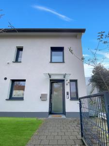 una casa blanca con una puerta y una puerta en Ferienhaus 500m zur Messe Hannover en Hannover