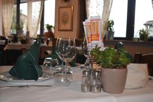 a table with glasses and plants on a white table cloth at Albergo Canella in Fuipiano Valle Imagna