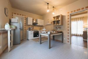 uma cozinha com uma mesa e um frigorífico em La Favola em Soriso