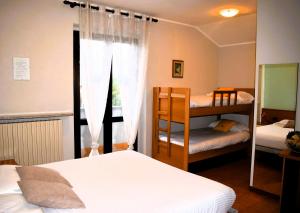 a bedroom with two bunk beds and a window at Albergo Canella in Fuipiano Valle Imagna