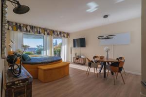 Studio-Apartments La Selva في غيفّا: غرفة معيشة مع سرير وغرفة طعام