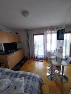 1 dormitorio con 1 cama y cocina con ventanas en Joli studio avec terrasse et vue EXCLUSIVEMENT POUR NON FUMEURS en Belmont-sur-Lausanne