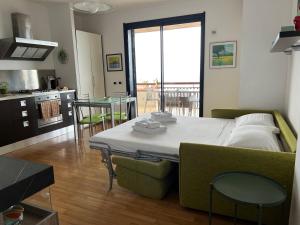 Una habitación con una cama y una mesa y una cocina. en Chez Marie, en Taormina