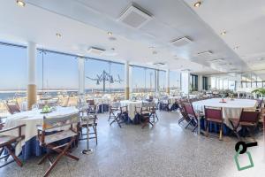 a dining room with tables and chairs and large windows at HOTIDAY Gallipoli Porto in Gallipoli