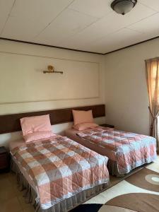 2 letti posti uno accanto all'altro in una camera da letto di MA Villa 993, A Famosa Resort a Kampong Alor Gajah