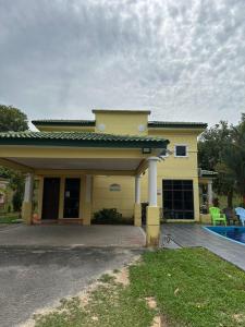 une grande maison jaune avec une grande allée. dans l'établissement MA Villa 993, A Famosa Resort, à Kampong Alor Gajah
