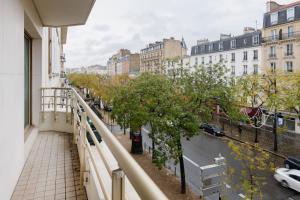einen Balkon mit Blick auf eine Straße und Gebäude in der Unterkunft Paris Beaugrenelle Residence in Paris