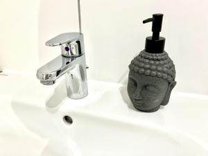 a bathroom sink with a statue next to a faucet at City Appartement Küche,Bad, Parken im Zentrum von Ravensburg in Ravensburg