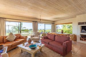 uma sala de estar com dois sofás e uma mesa em Tidal Retreat em Plettenberg Bay