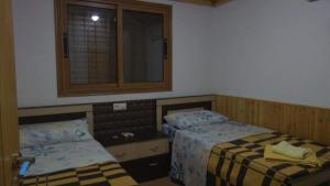 a bedroom with two beds and a window and a mirror at Bujtina Anesi in Poliçan +62 photos